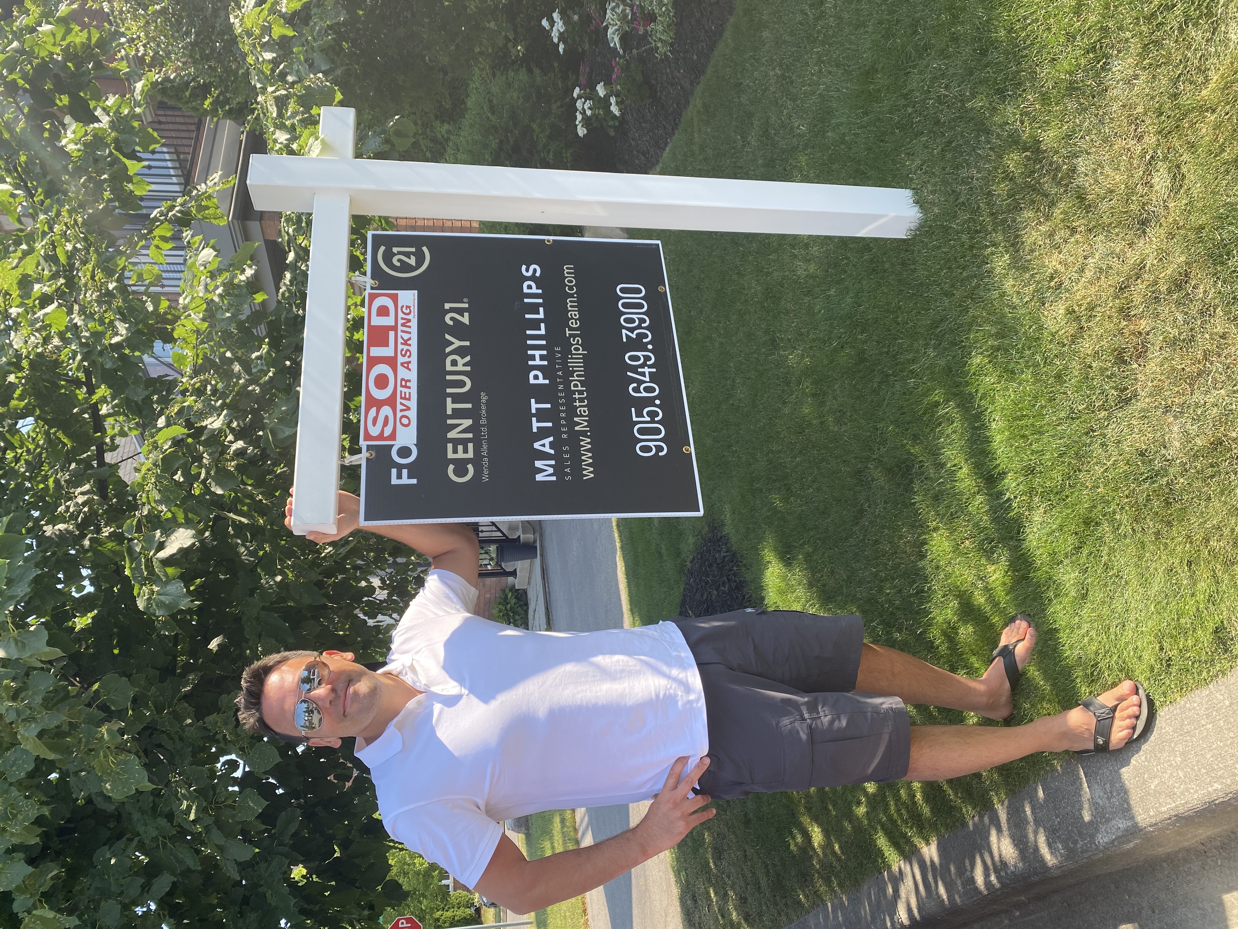 Low Commission Real Estate Agent Standing Beside His For Sale Sign In Ajax Ontario